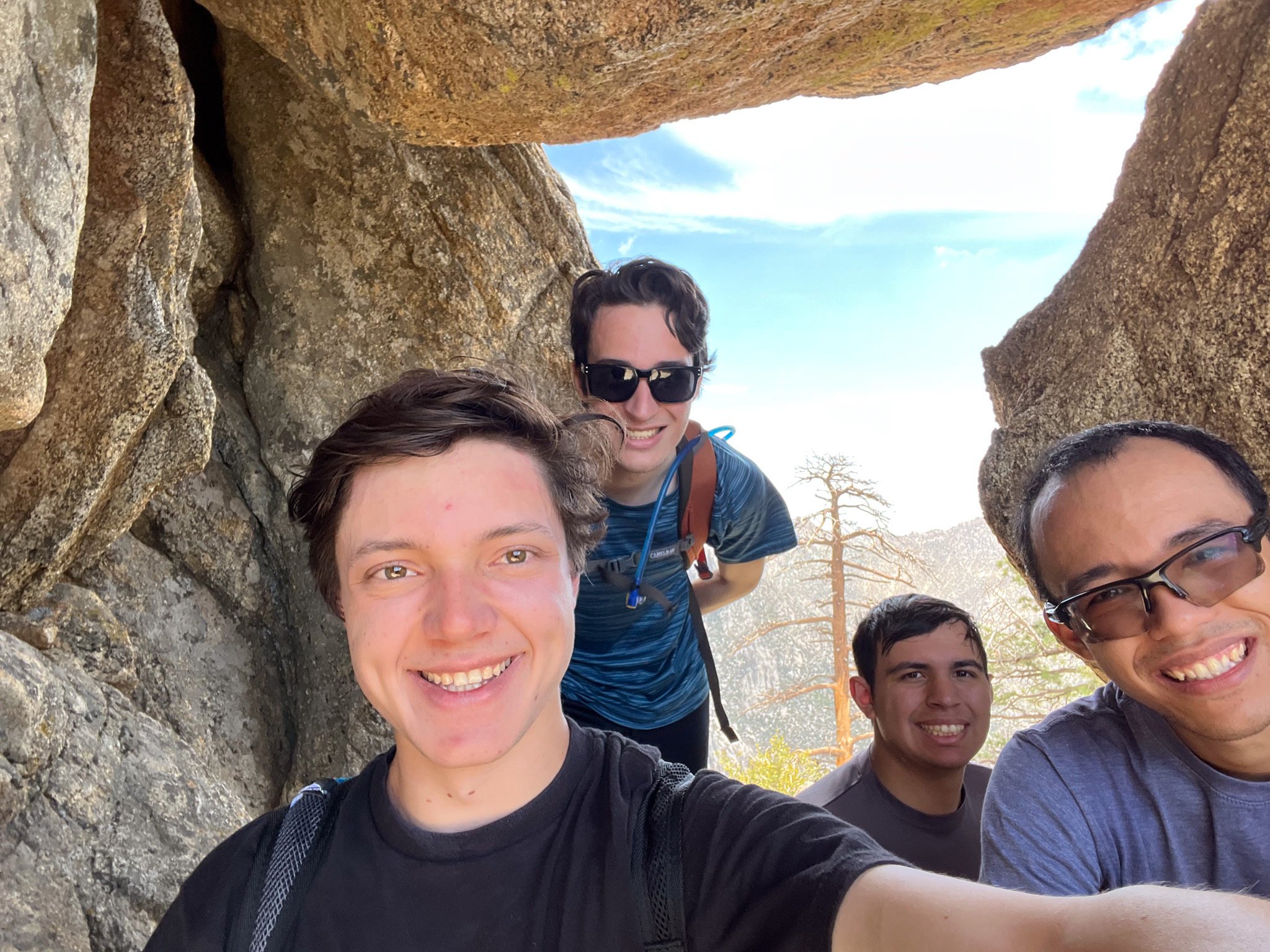 Four friends on a hiking trip taking a picture.